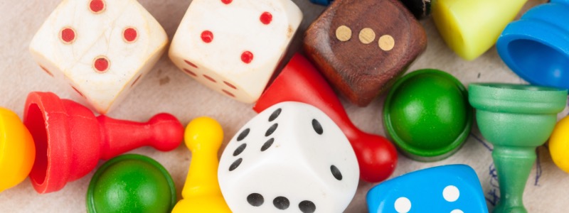 Bunte Würfel und Spielfiguren wild durchgemischt liegend