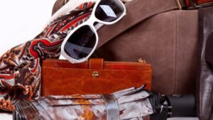 Auswahl an Festival-Kleidung mit Sonnenbrille, Tasche, und Shorts flach arrangiert